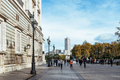 People on street against buildings in city