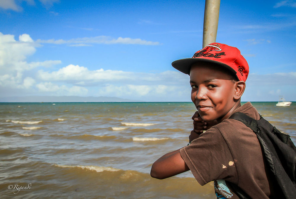 PORTRAIT OF BOY STANDING AGAINST SEA