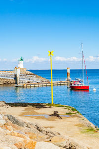 Sailboat on beach against blue sky