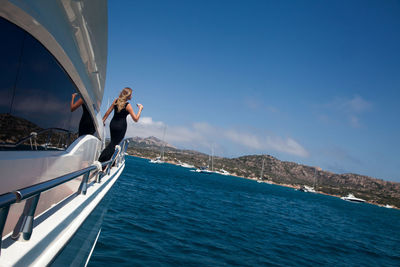 Young woman sailing on sea against sky