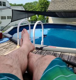 Low section of man legs in swimming pool