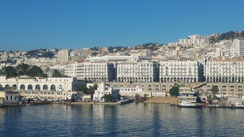 View of cityscape against clear blue sky