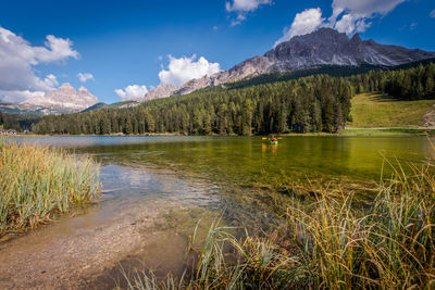 Scenic view of lake by mountains against sky