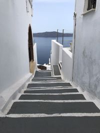 Staircase leading towards sea against sky