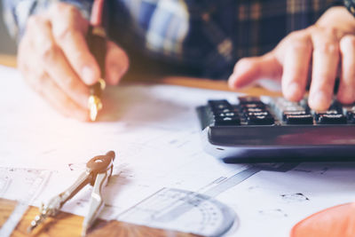 Cropped hands of architect working at table