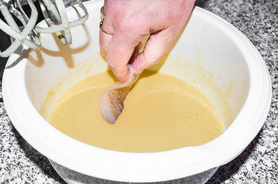 Close-up of hand holding fish in bowl