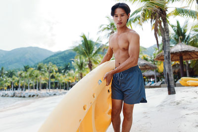 Full length of shirtless man standing in sea