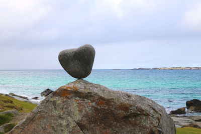 Scenic view of rocks on beach against sky