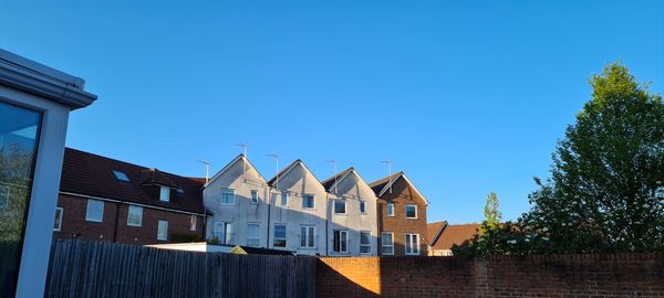 Low angle view of buildings against clear blue sky