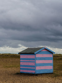 Pink and blue wooden beach hut against grey sky great yarmouth 