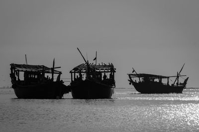 Ship moored in sea against clear sky