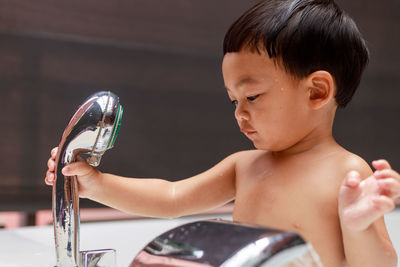 Portrait of shirtless boy looking at camera