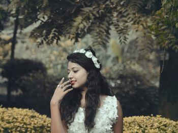 Beautiful woman standing against plants at park