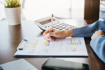 Midsection of businessman working on table