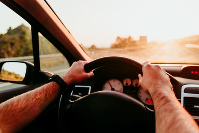 Cropped hand of man driving car