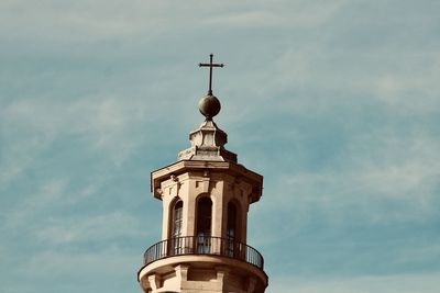 Low angle view of cross tower against sky