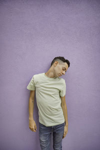 Portrait of young man standing against wall