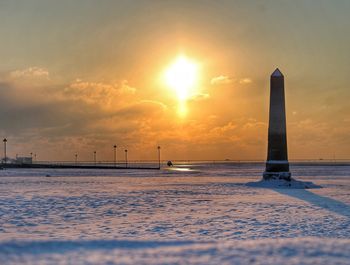 Scenic view of snow covered land against sky during sunset