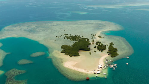 Beach on tropical island surrounded by coral reef, sandy bar with tourists. honda bay. luli island. 