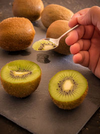 Close-up of hand holding fruits on table