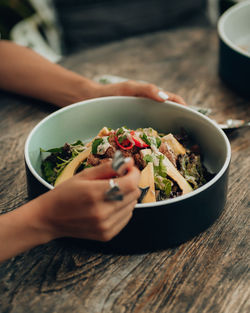 High angle view of woman holding bowl on table