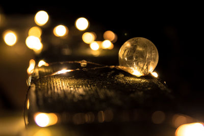 Close-up of illuminated light bulb against sky