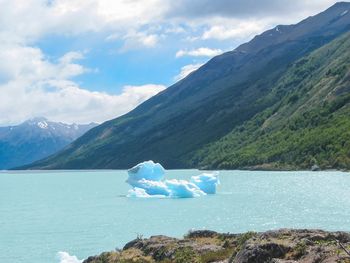Scenic view of sea and mountains against sky