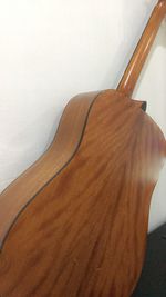 High angle view of guitar on table against white wall