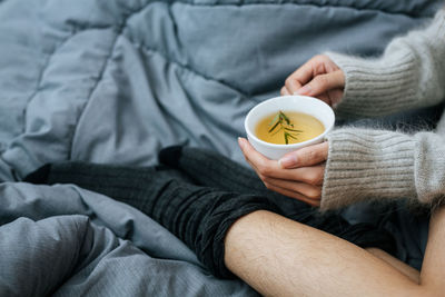 Midsection of woman holding coffee at home