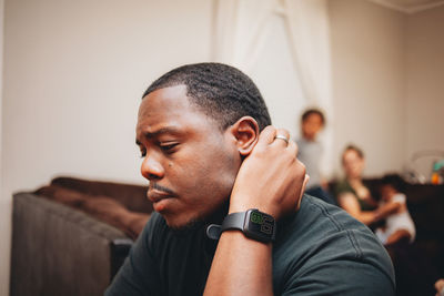 Close-up of man looking away while sitting at home