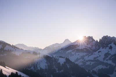 Scenic view of snowcapped mountains against clear sky