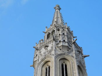 The peak of matthias church in budapest, hungary against a clear blue sky