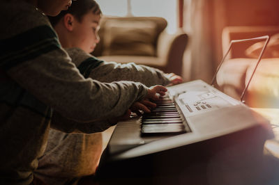 Boys playing piano at home