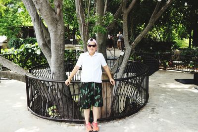 Portrait of young man standing against trees