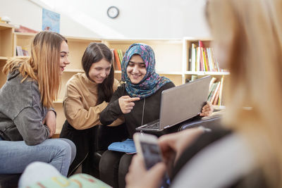 Teenage girls sitting together in library