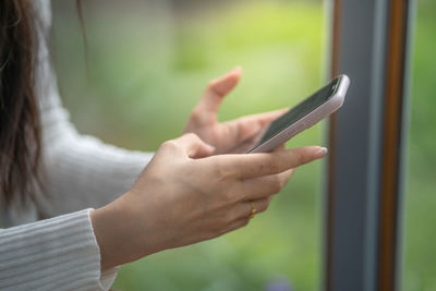 Midsection of woman holding mobile phone