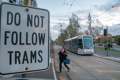 Train on railroad track in city against sky