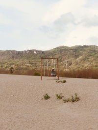 Beautiful view of the sand with a swing in the middle