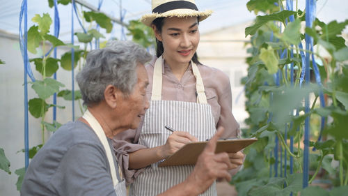 Portrait of a smiling young woman holding plant