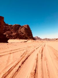 Panoramic view of desert land against clear blue sky