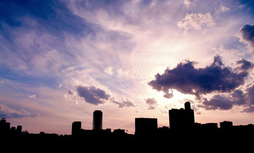 Silhouette buildings against sky during sunset