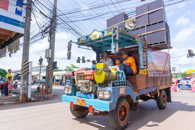 Vehicles on road against sky in city