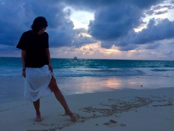 Woman writing with barefoot at beach