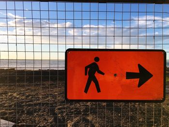 Close-up of road sign against sky