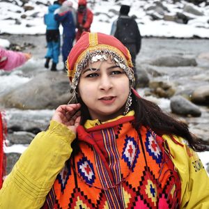 Young woman in traditional clothing standing outdoors