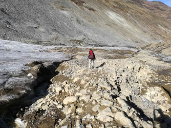 Man climbing on cliff against mountain