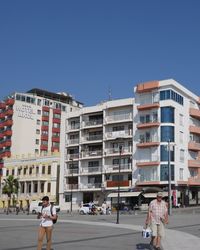 People on street against buildings in city