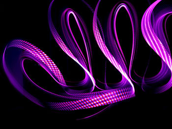 Illuminated purple abstract pattern against black background