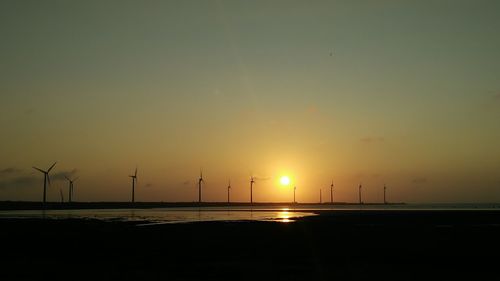 Silhouette of wind turbines at sunset