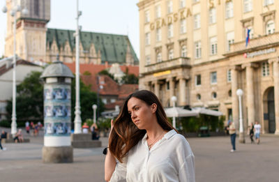 Portrait of attractive young woman in city